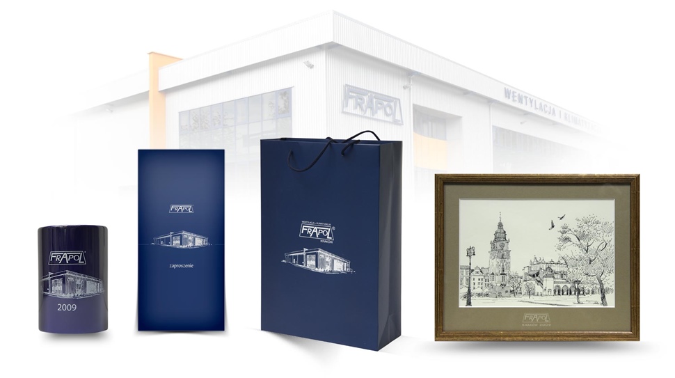 Kubek, zaproszenie, torba papierowa i grafika Piotra Kutryby na tle zdjęcia siedziby firmy Frapol